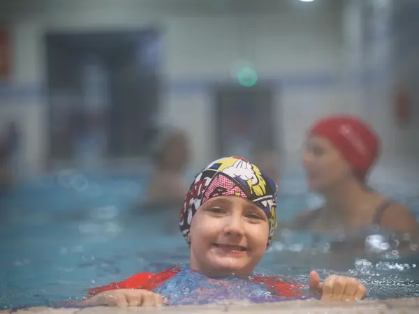 A young girl resting at the edge of the pool during a session