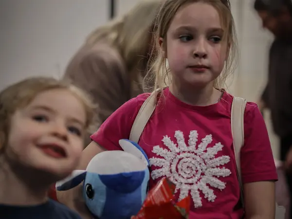 Two children smiling with their dolphin plush toys