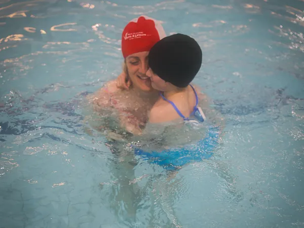 A mother giving her child a cuddle in the pool