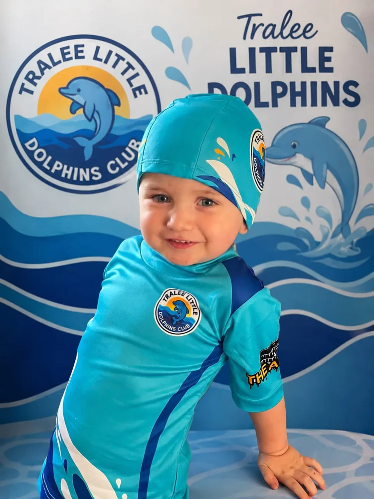 A young swimmer modelling the Tralee Little Dolphins swim cap and rash top